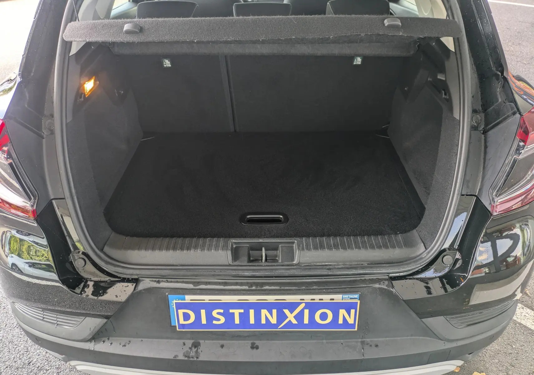 Coffre ouvert vu de l'arrière d'un Renault Captur noir 2020, montrant un espace de chargement vide et propre.
