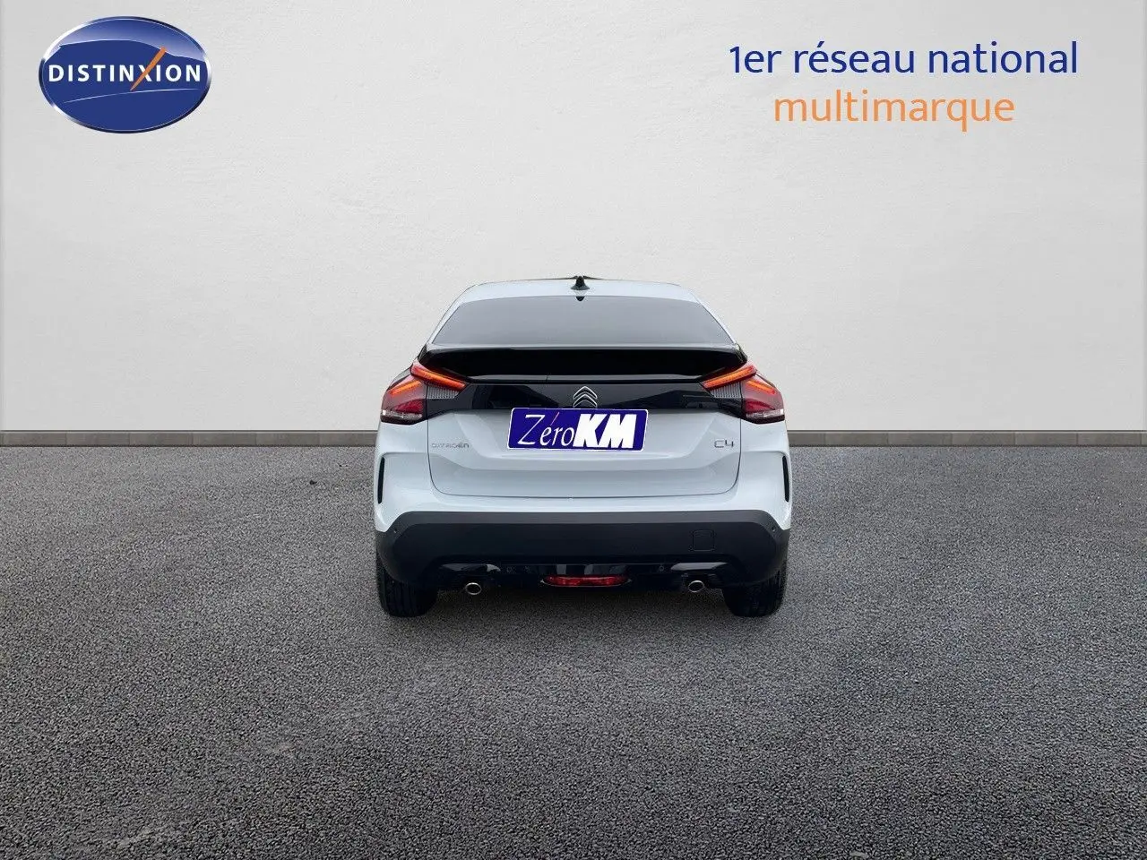 Vue arrière d'une Citroën C4 blanche métallisée 2024 avec feux LED et double sortie d'échappement visible.