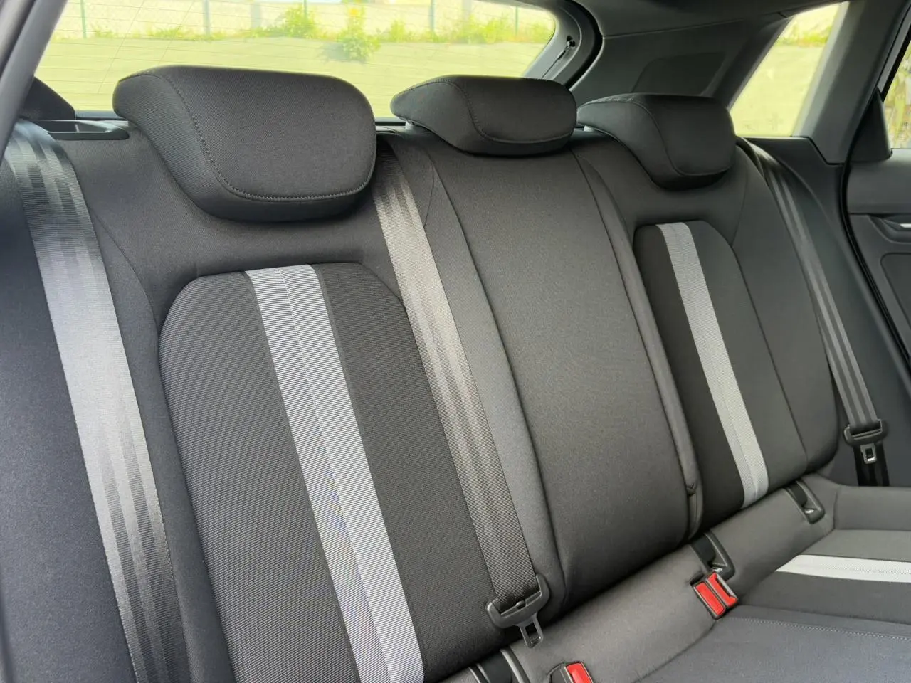 Vue rapprochée de la banquette arrière noire avec bandes grises de l'Audi A3 Sportback 2024, intérieur tissu Konsens.