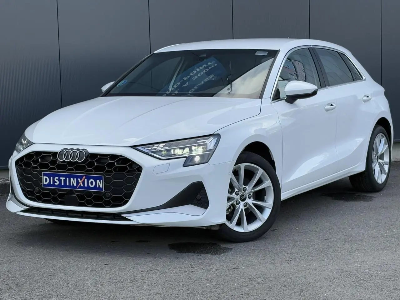 Audi A3 Sportback blanc Arkona vue 3/4 avant droit avec calandre hexagonale noire et jantes alliage 17 pouces.