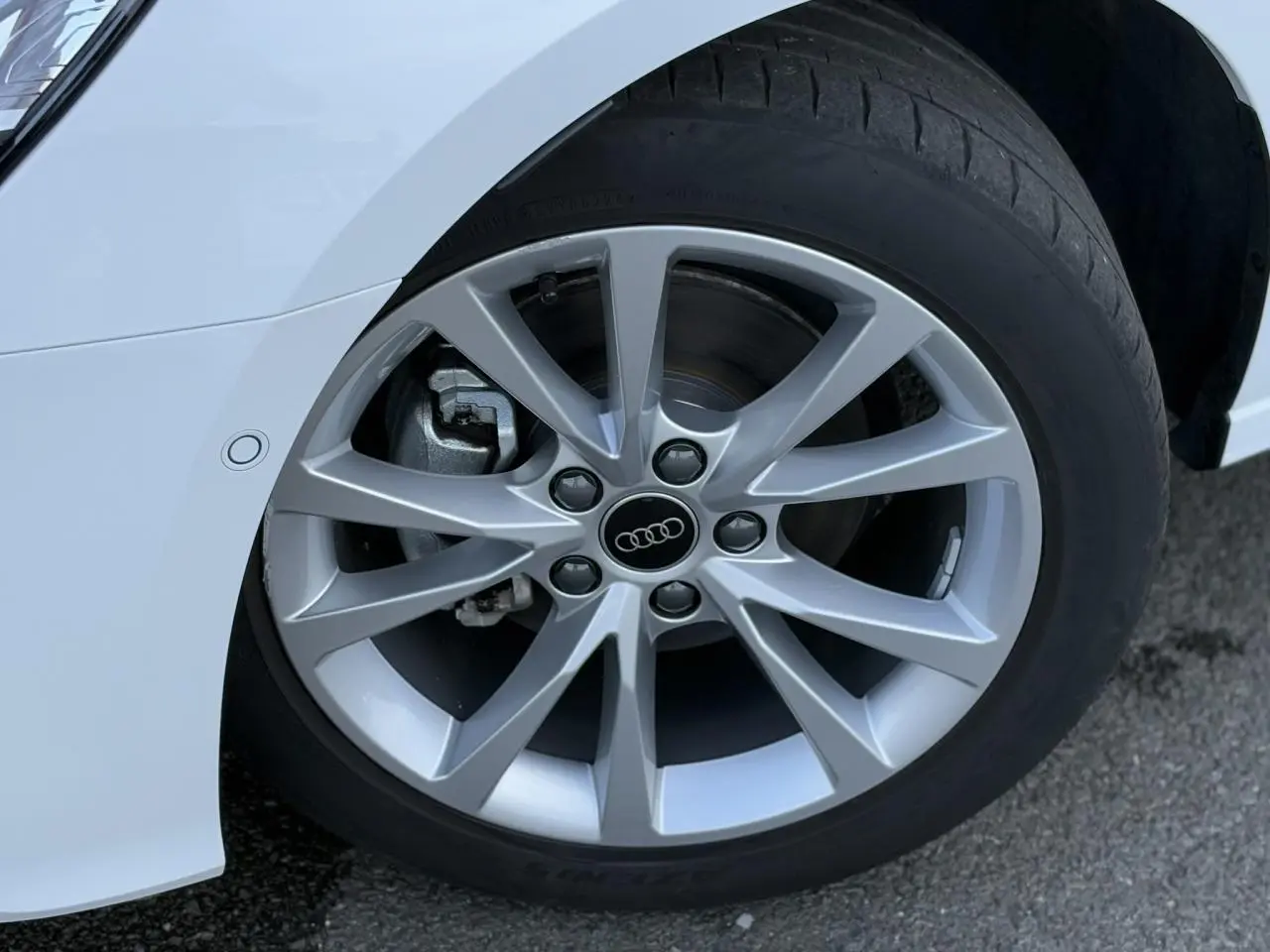 Gros plan sur la jante alliage 17 pouces et pneu du côté avant gauche de l'Audi A3 Sportback blanc Arkona.