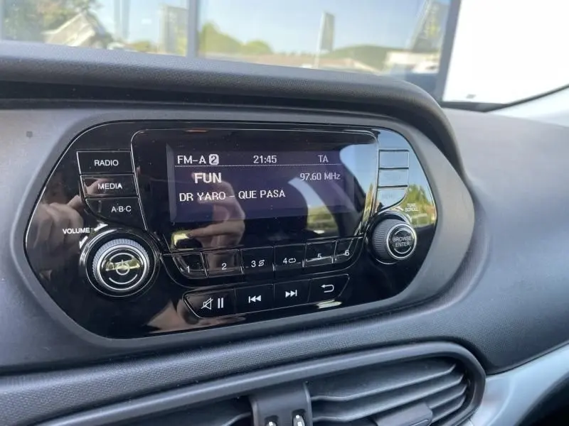 Gros plan sur la console centrale de la Fiat Tipo 2019, affichant l'autoradio FM avec écran digital noir.