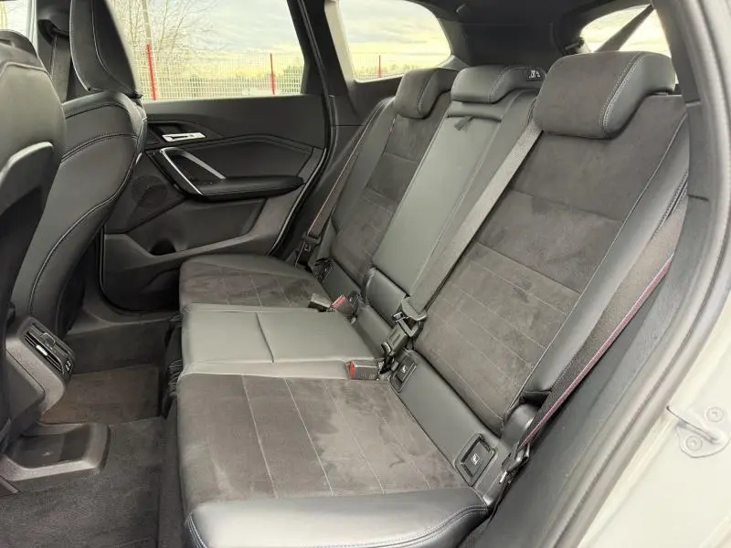 Vue latérale intérieure montrant la banquette arrière en alcantara noir du BMW X1 XDrive20d Spacesilber métal 2025.