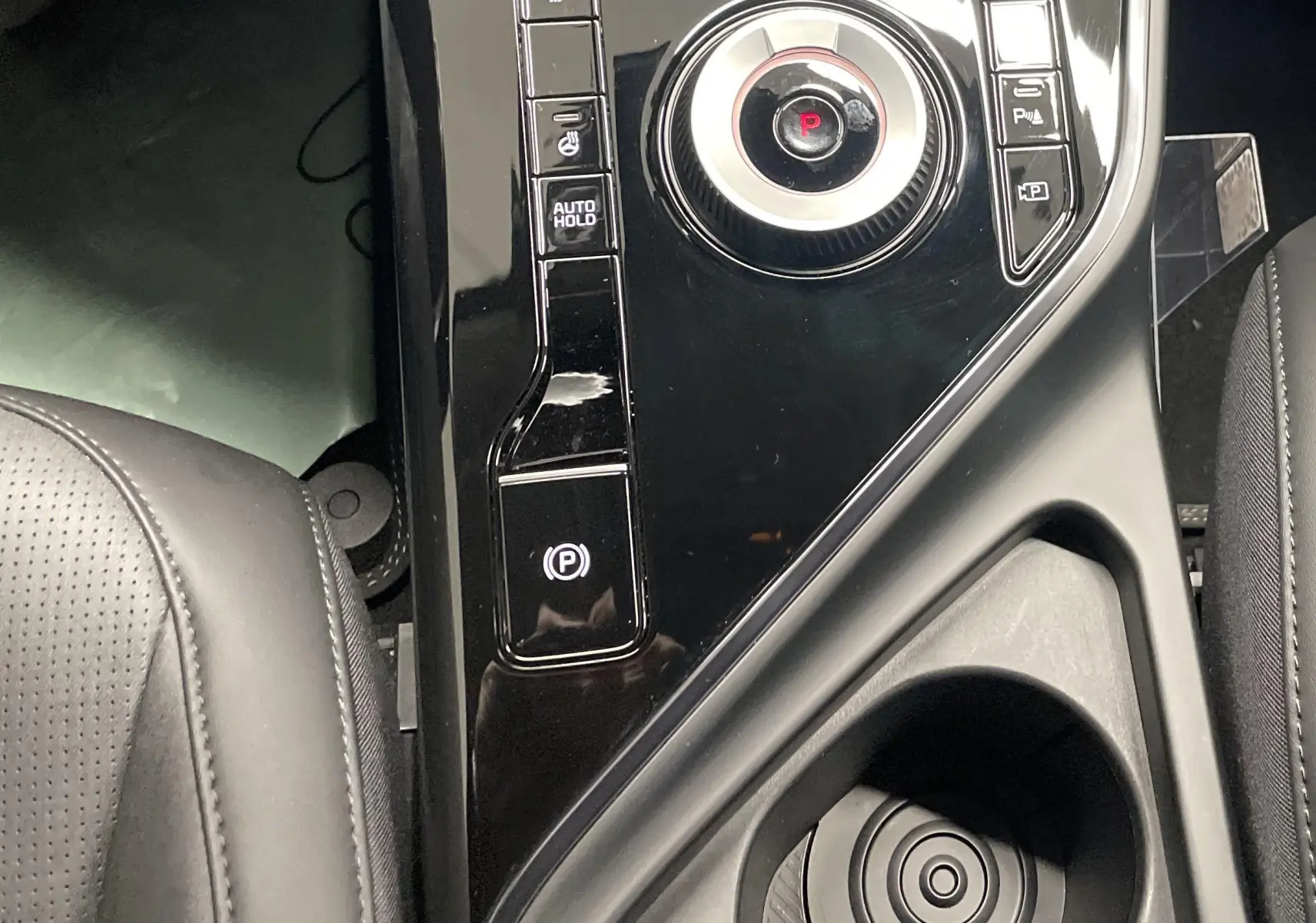 Console centrale noire avec molette de sélection et boutons de frein à main dans l'habitacle du Kia Niro hybride 2025.