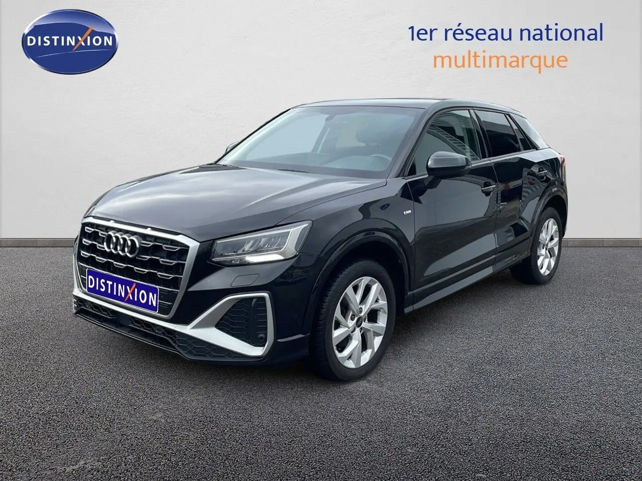 Audi Q2 noir mito metal en vue 3/4 avant droit, mettant en valeur sa calandre S-Line et ses jantes argentées.