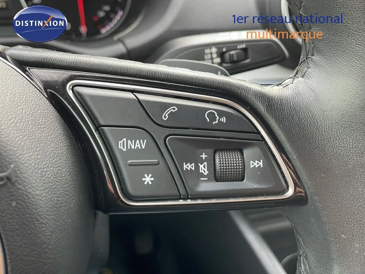 Gros plan sur les commandes multimédia au volant en cuir noir de l'Audi Q2 35 TFSI S-Line 2023.