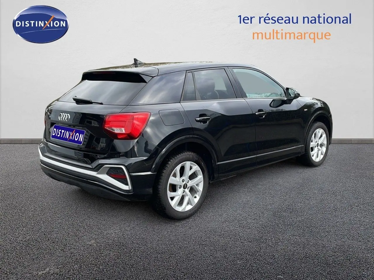 Audi Q2 noir mito metal vue 3/4 arrière droit, soulignant ses feux arrière rouges et jantes argentées.