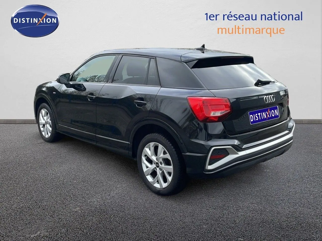 Audi Q2 noir mito metal vue 3/4 arrière côté gauche, mettant en valeur ses feux arrière et jantes argentées.