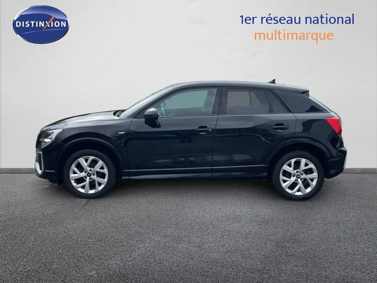 Profil côté gauche d'un Audi Q2 35 TFSI S-Line noir mito metal, avec jantes alliage et lignes épurées visibles.