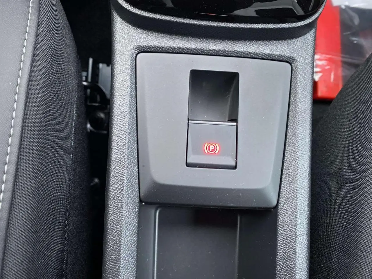 Gros plan sur le frein de stationnement électrique activé dans la console centrale du Citroën C3 Aircross hybride 2025.