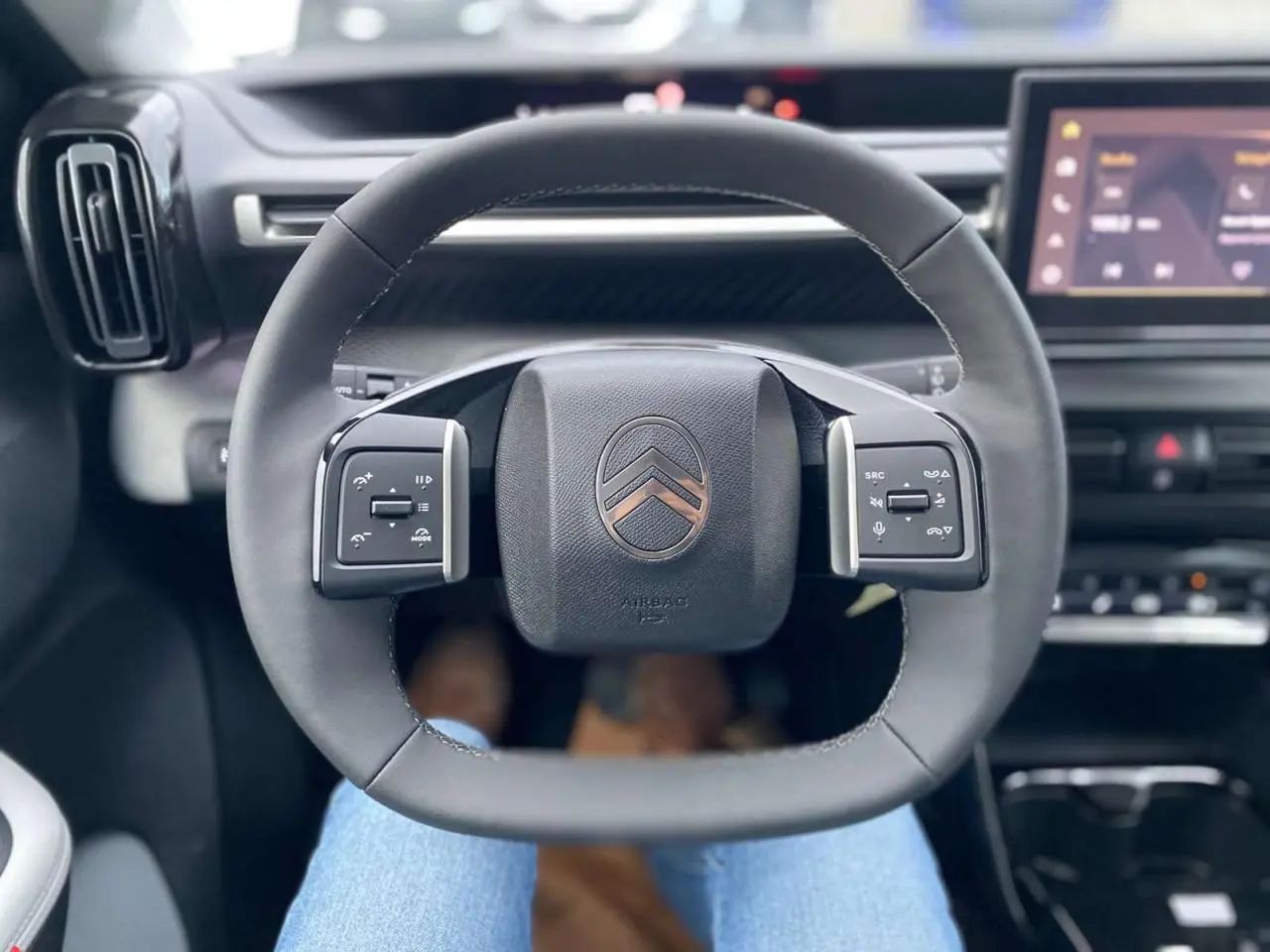 Volant multifonctions Citroën C3 Aircross 2025 vu de face avec tableau de bord et écran tactile en arrière-plan
