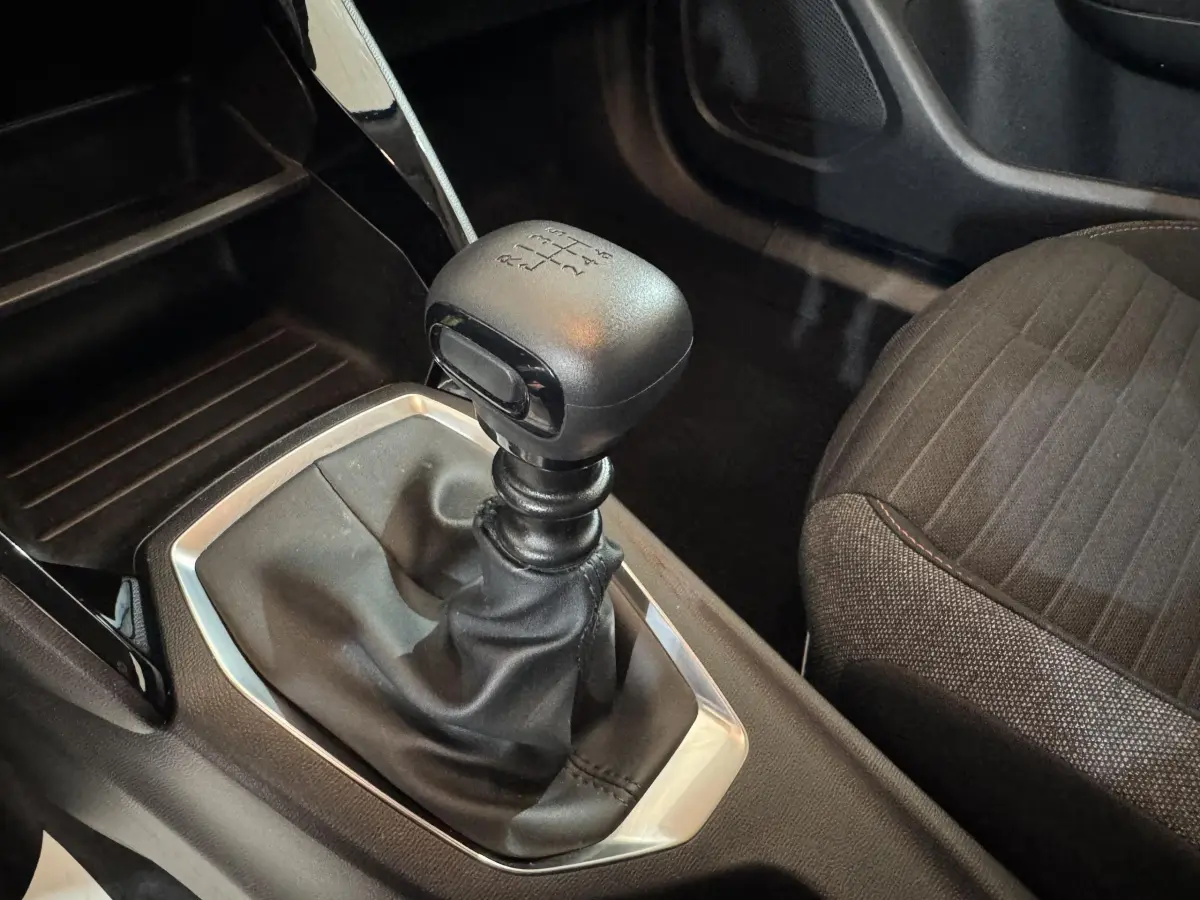 Gros plan sur le levier de vitesses manuel noir et la sellerie tissu gris à motifs du Peugeot 2008 PureTech 130 S&S Active Pack.