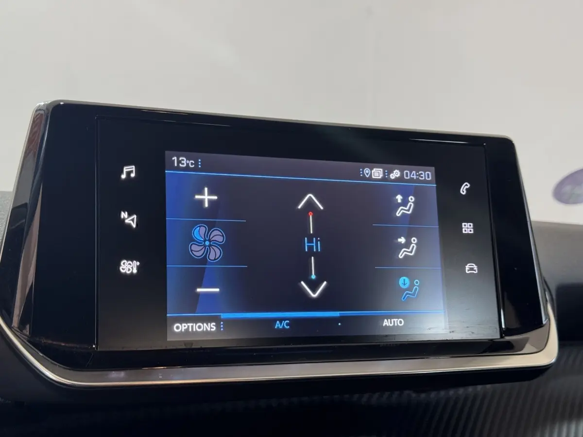 Écran tactile central de la Peugeot 2008 noir, affichant les commandes de climatisation en intérieur.