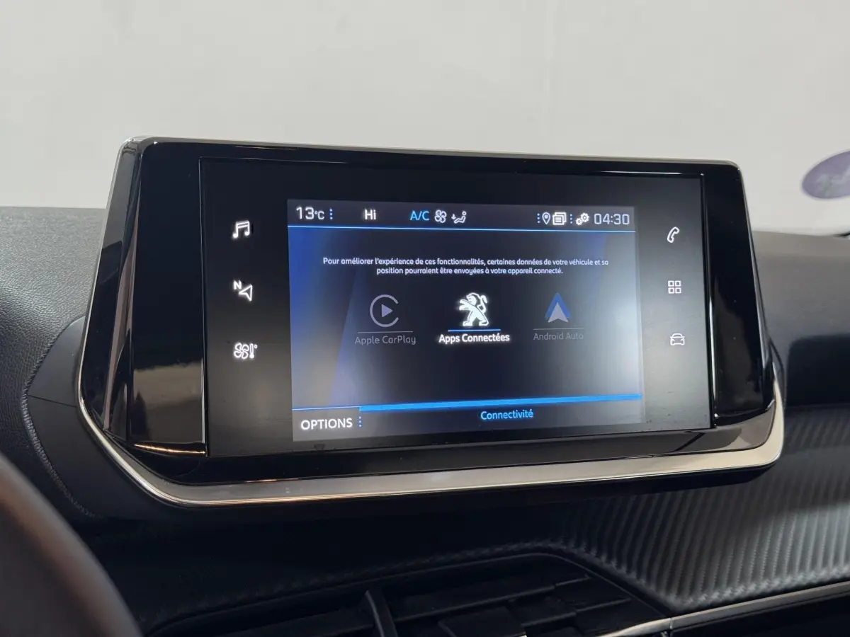 Écran tactile central affichant Apple CarPlay et Android Auto dans le tableau de bord du Peugeot 2008 noir.