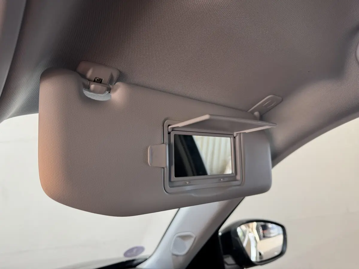 Miroir de courtoisie ouvert sur pare-soleil côté conducteur dans l’habitacle d’un Peugeot 2008 noir.