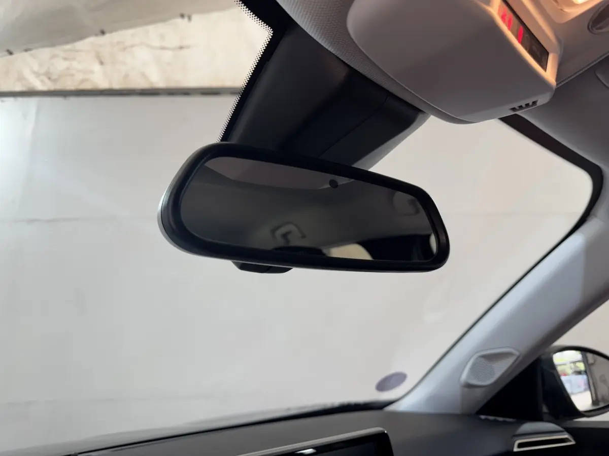 Vue intérieure du rétroviseur central d’une Peugeot 2008 noire, avec partie du tableau de bord et vitre latérale visibles.