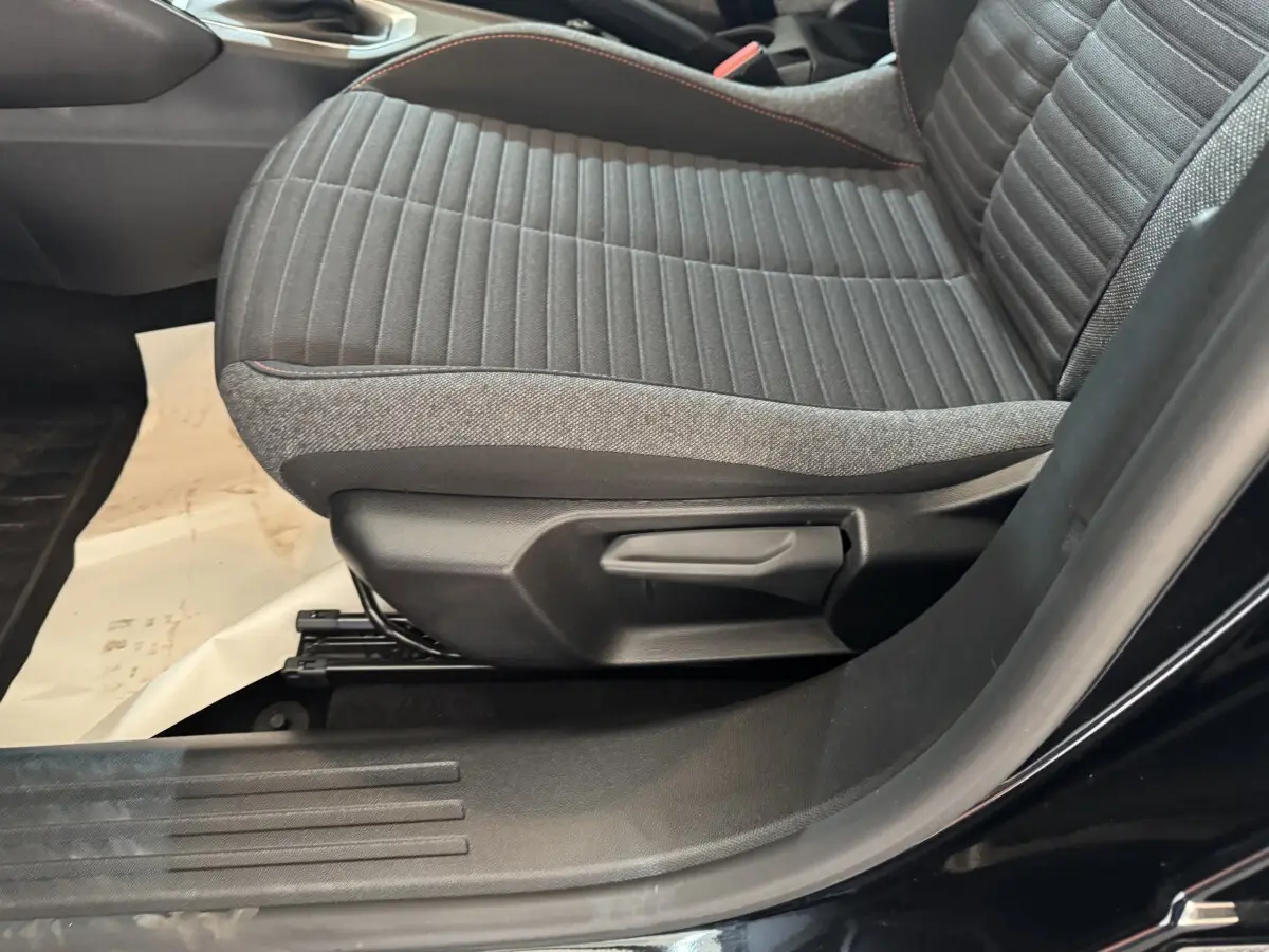 Gros plan sur le siège avant droit gris à surpiqûres rouges du Peugeot 2008 noir, version PureTech 130 S&S ACTIVE PACK.