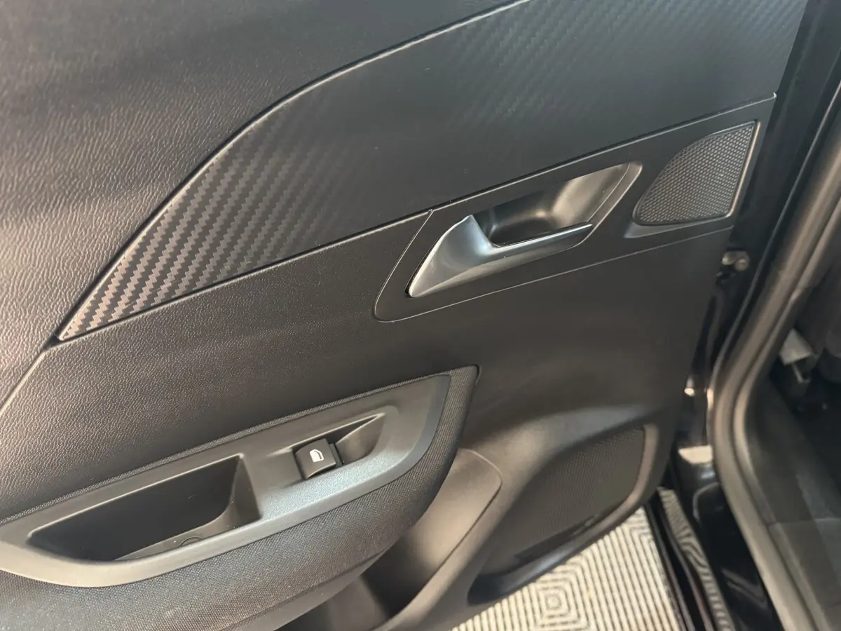 Détail de la porte arrière droite noire du Peugeot 2008 2022 avec poignée argentée et bouton de verrouillage.