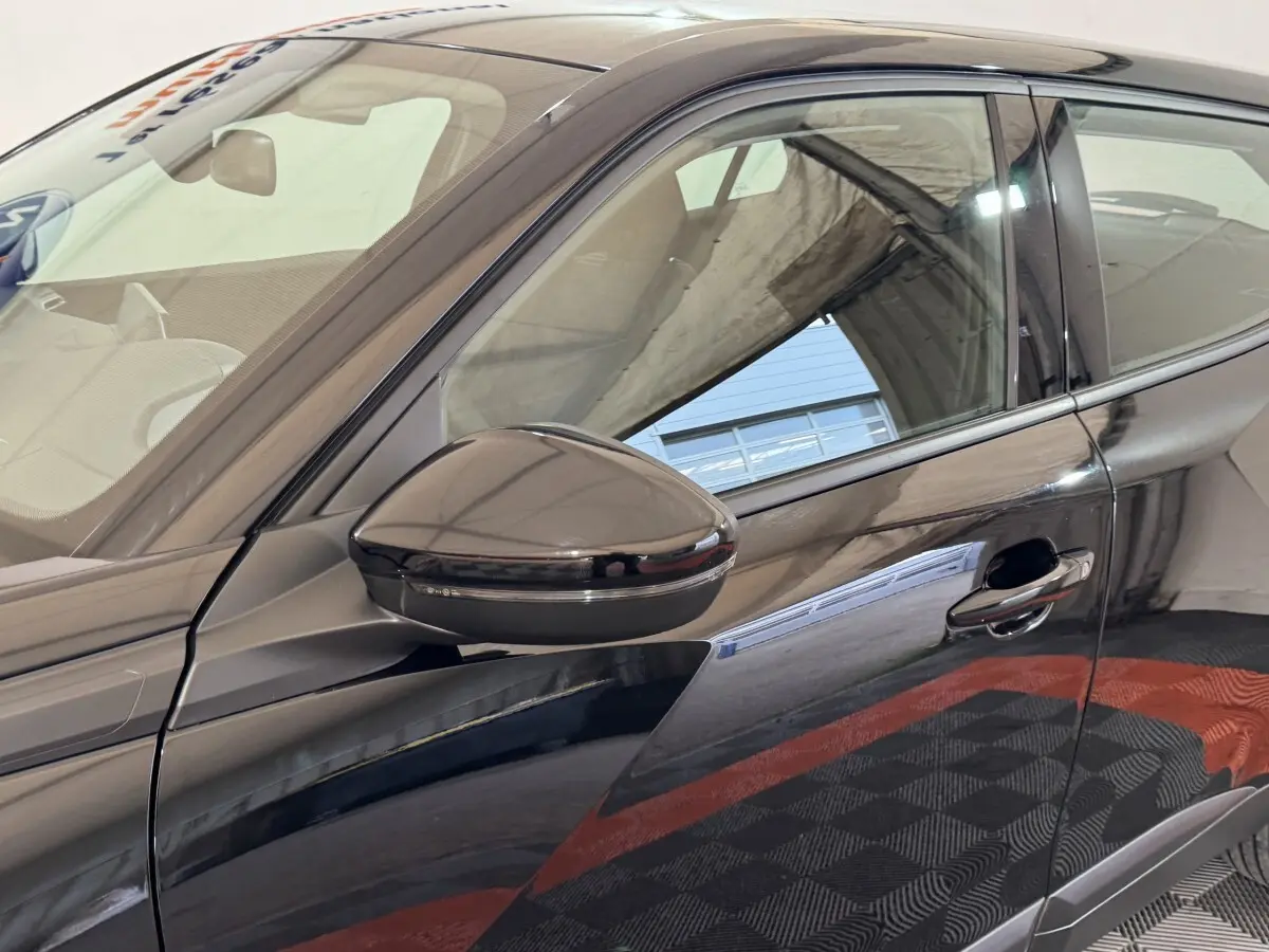 Détail du côté gauche d’un Peugeot 2008 noir 2022, avec rétroviseur et poignée de porte visibles.