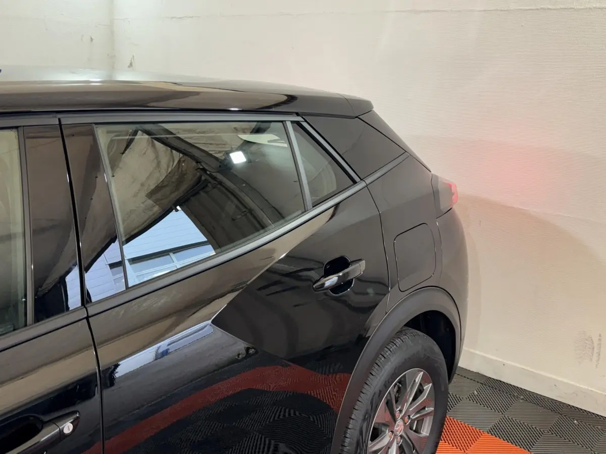 Vue latérale arrière droite d’un Peugeot 2008 noir brillant, mettant en valeur la porte arrière et la roue.