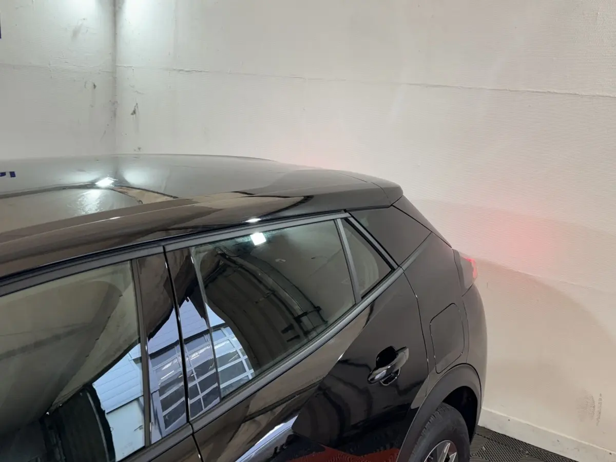 Vue arrière côté droit d’un Peugeot 2008 noir brillant, mettant en valeur la ligne de toit et la porte arrière.