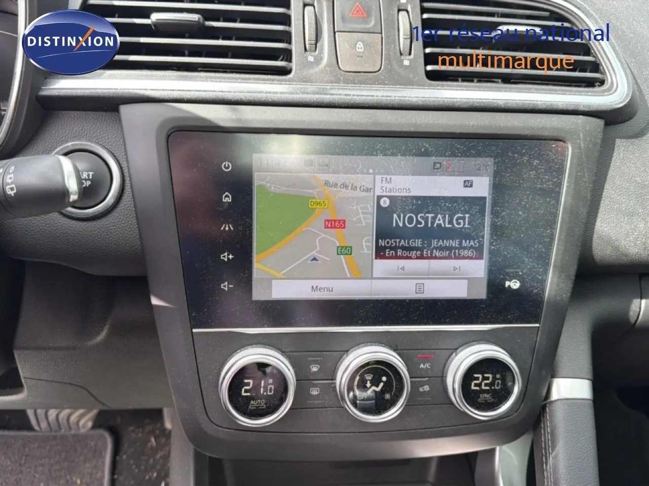 Vue rapprochée de la console centrale du Renault Kadjar gris Highland, avec écran tactile et commandes de climatisation.