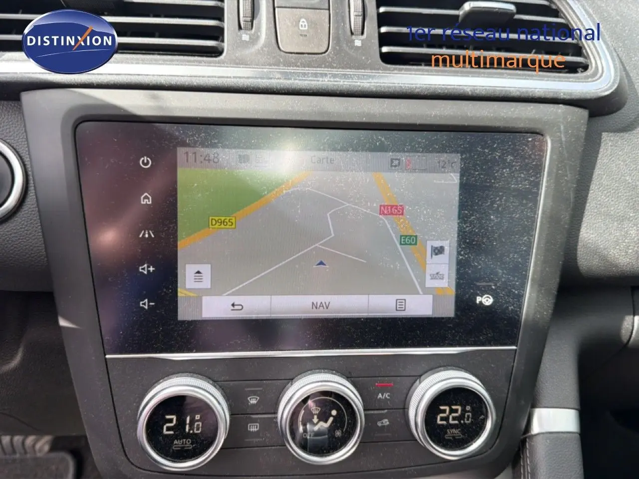 Vue rapprochée de l’écran tactile et des commandes de climatisation du tableau de bord d’un Renault Kadjar gris Highland.