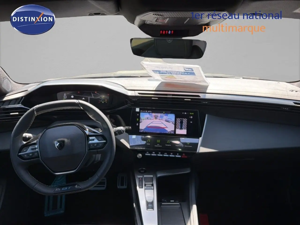 Vue intérieure avant du tableau de bord noir de la Peugeot 308 Hybrid 145ch GT avec écran tactile et volant multifonction.