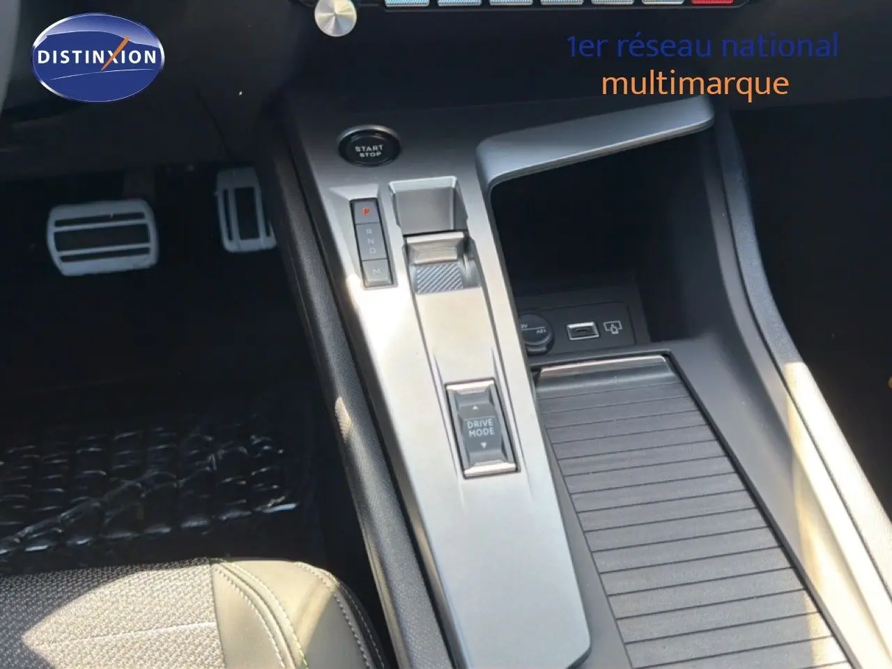 Gros plan sur la console centrale de la Peugeot 308 Hybrid 145ch GT 2026, montrant la commande de boîte auto et le bouton Drive Mode.