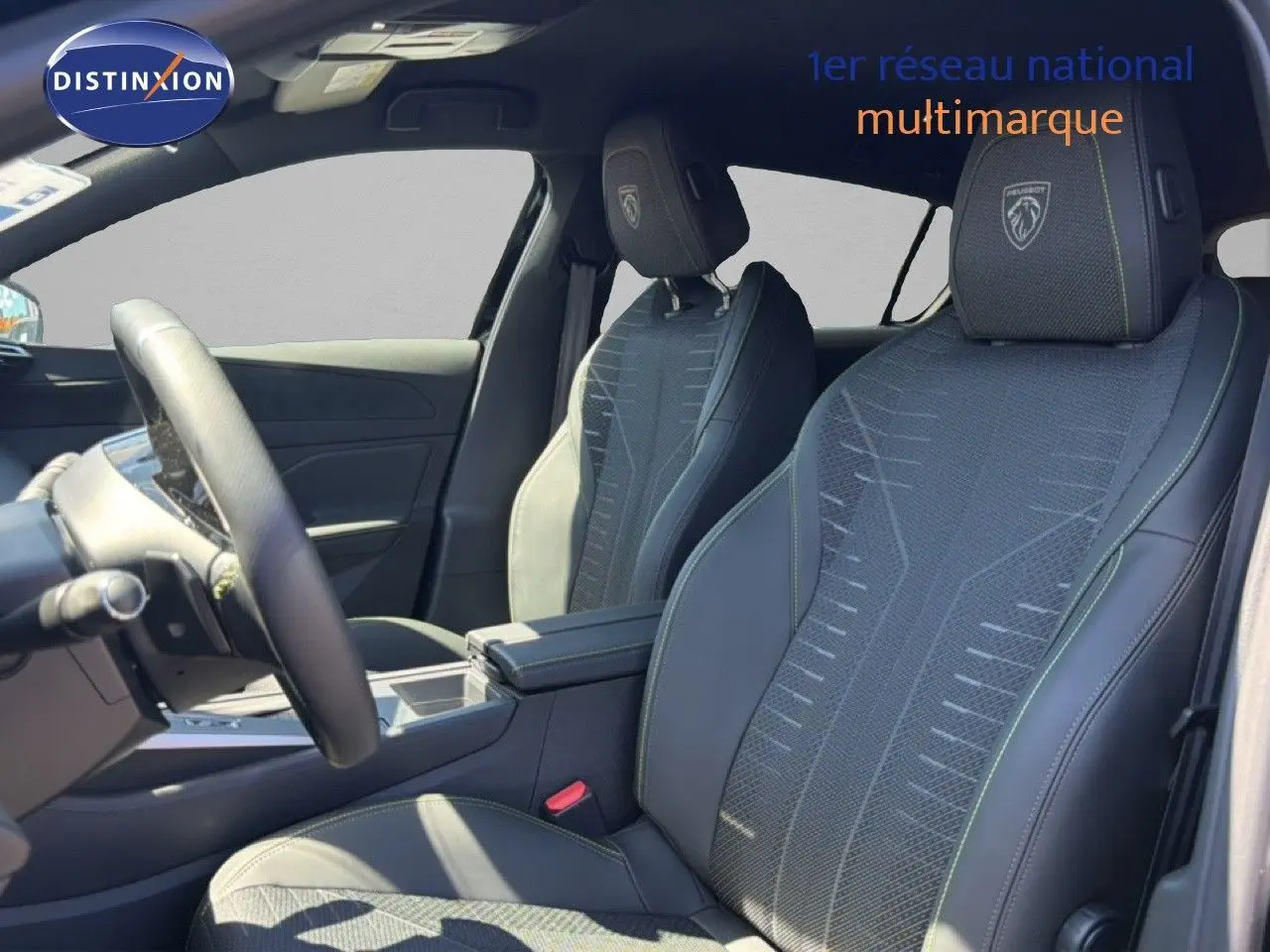 Intérieur de la Peugeot 308 Hybrid 145ch GT 2026, vue côté gauche sur sièges noirs avec surpiqûres vertes et logo Peugeot brodé.