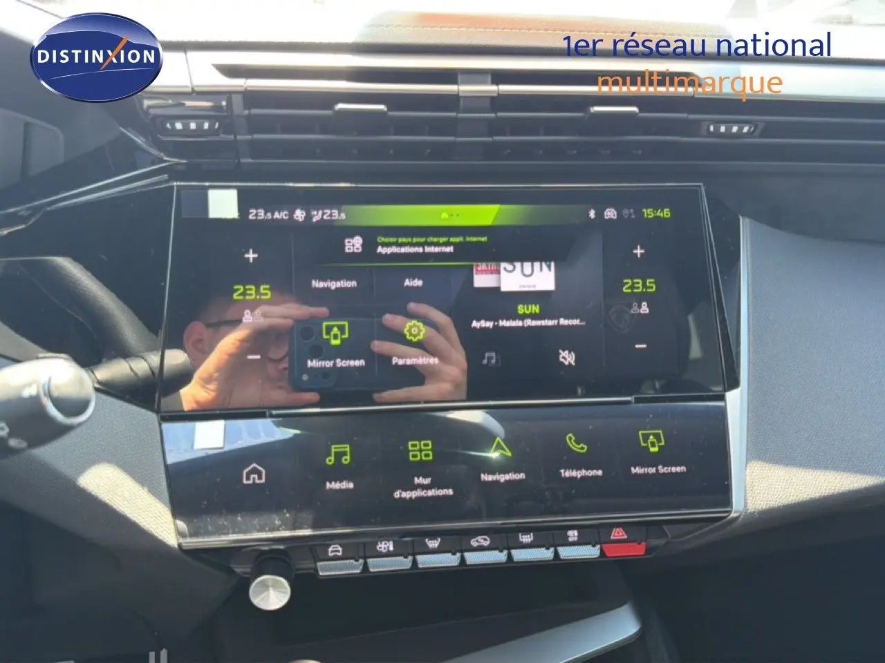 Vue rapprochée de l’écran tactile central noir brillant de la Peugeot 308 Hybrid 145ch GT, affichant les options multimédia.