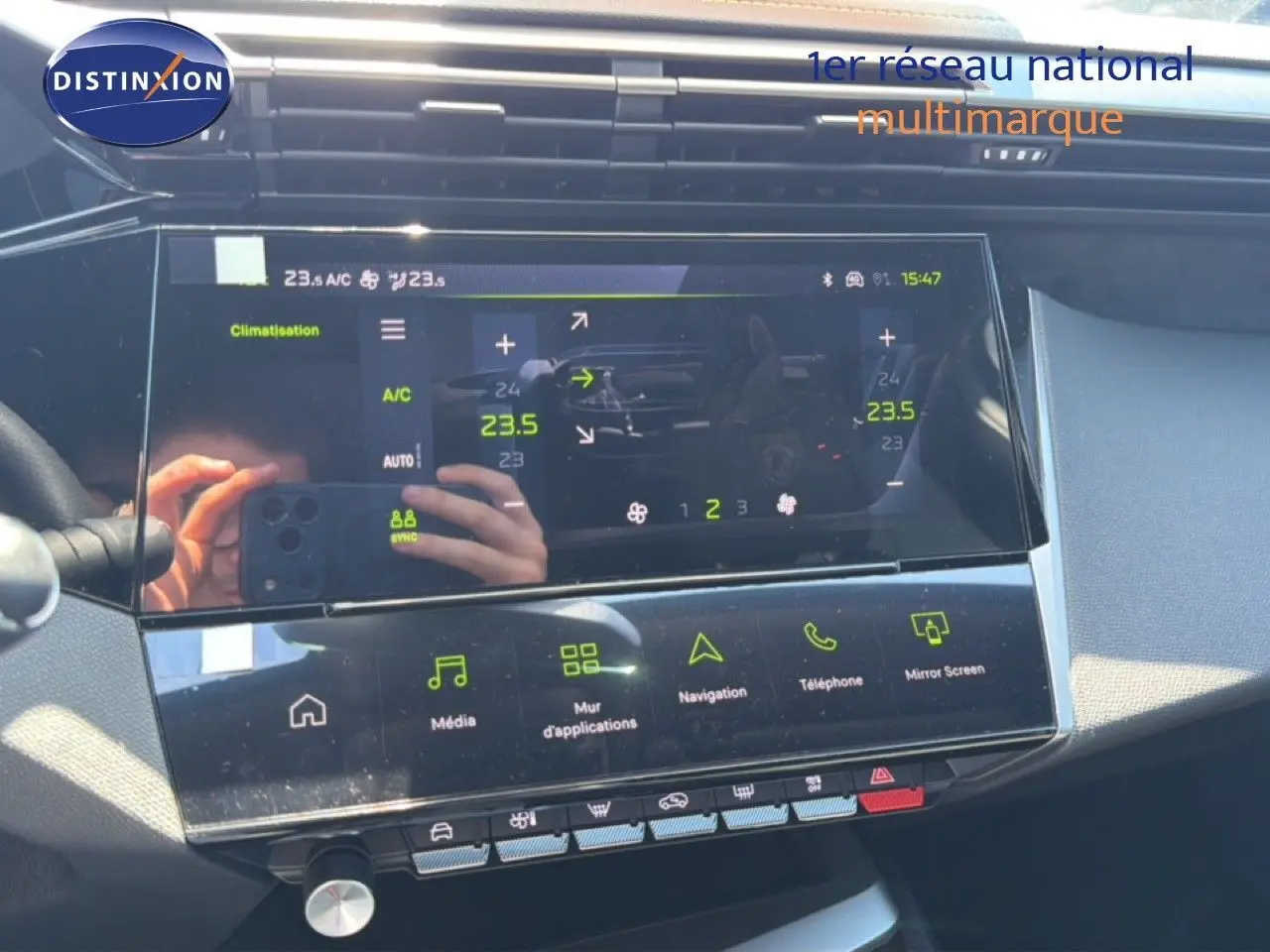 Vue rapprochée de l’écran tactile central de la Peugeot 308 Hybrid 145ch GT, affichant la climatisation et les options multimédia.