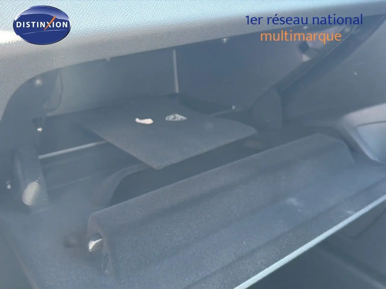 Gant de rangement ouvert côté passager montrant l'intérieur noir avec tapis et compartiment de la Peugeot 308 Hybrid 2026.