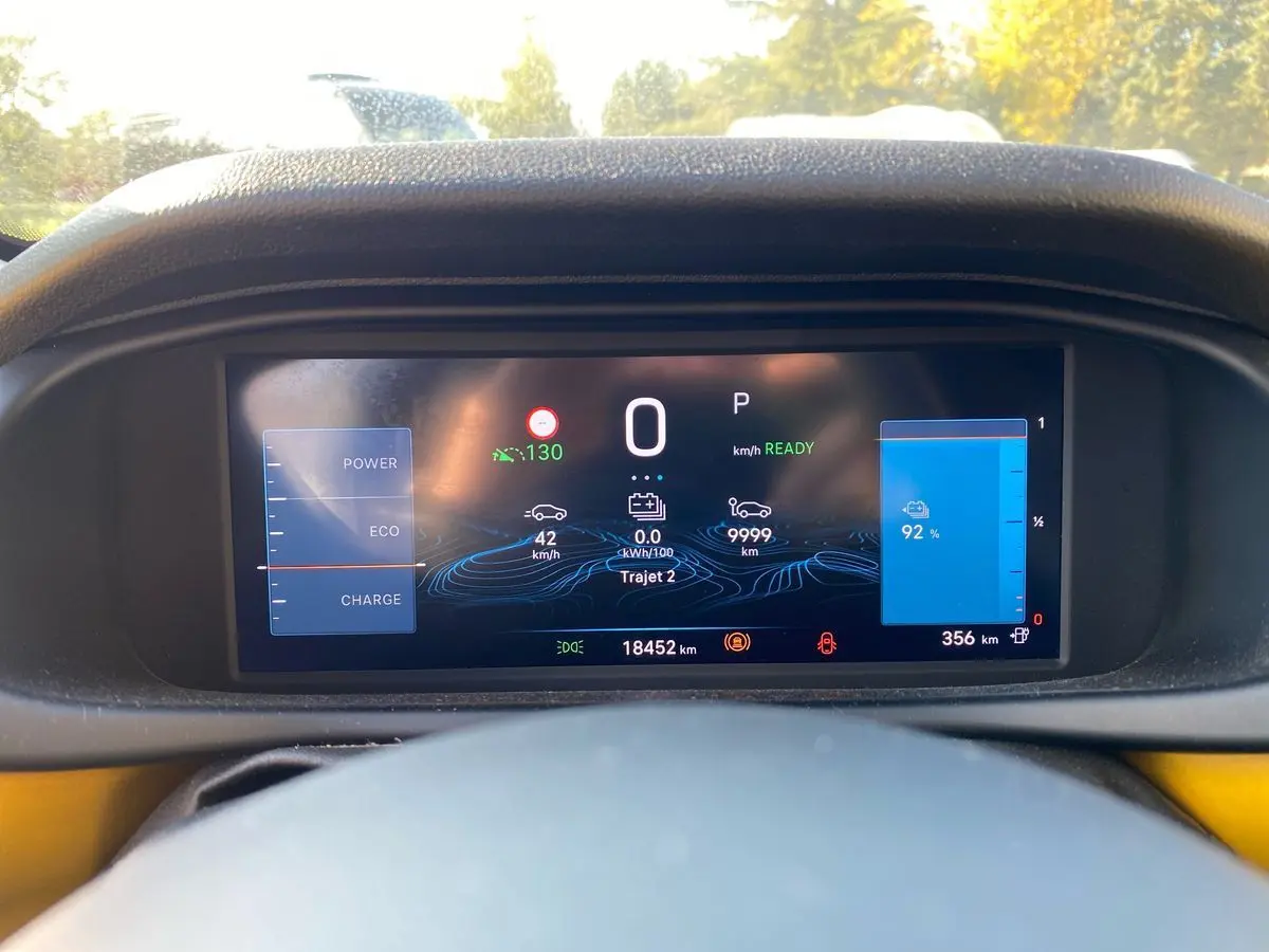 Vue du tableau de bord numérique du Jeep Avenger électrique 2023, affichant l'autonomie et la vitesse à l'arrêt.