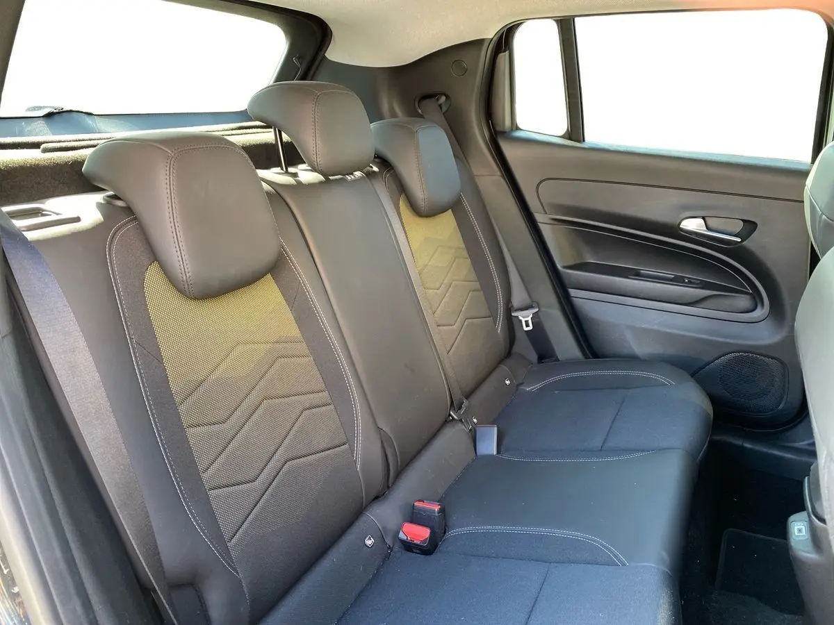 Vue intérieure côté droit des sièges arrière noirs du Jeep Avenger électrique 2023 avec ceinture et porte.