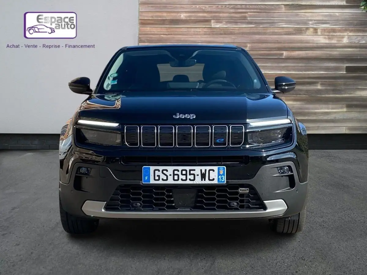 Vue de face d'un Jeep Avenger électrique noir 2023 avec calandre à sept barres et logo bleu "e" distinctif.