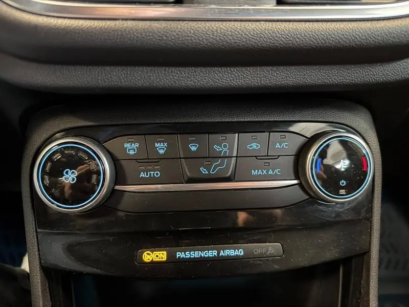 Panneau de commande de climatisation automatique du Ford Puma blanc, avec réglages ventilateur et température visibles.