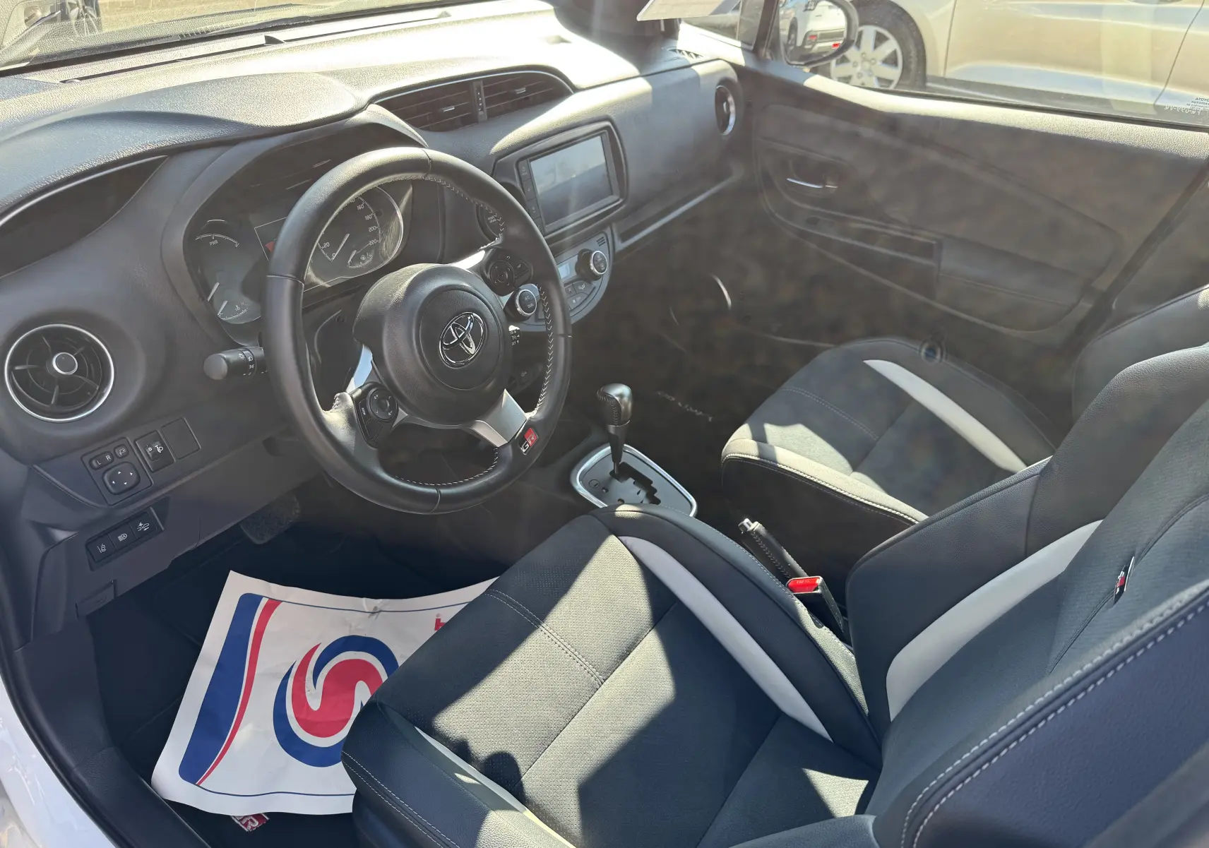 Intérieur de la Toyota Yaris Hybride 100CH GR SPORT 2020 vu côté conducteur, sièges noirs avec surpiqûres blanches.