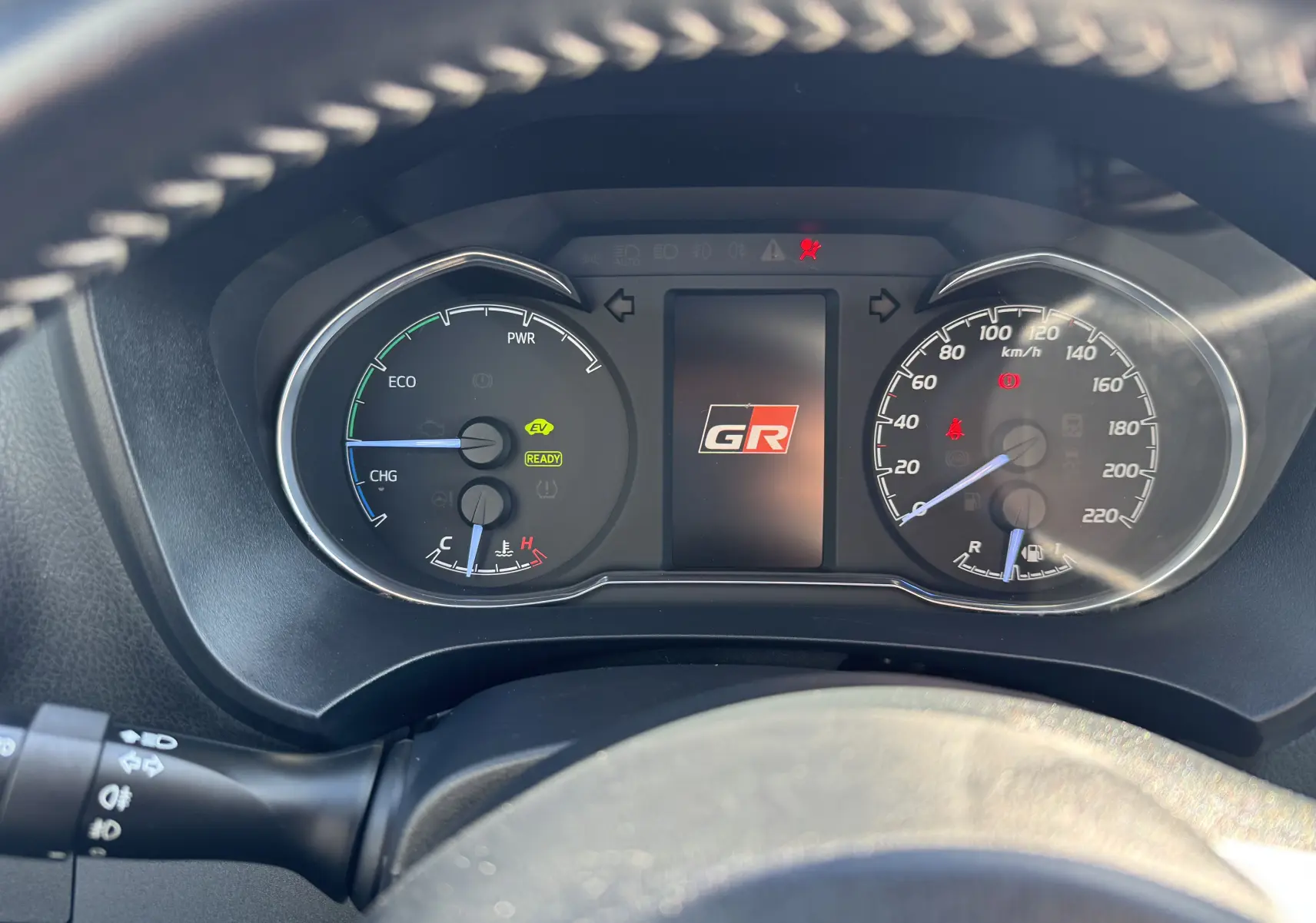 Vue rapprochée du tableau de bord de la Toyota Yaris Hybride GR Sport 2020 avec affichage numérique et logo GR central.