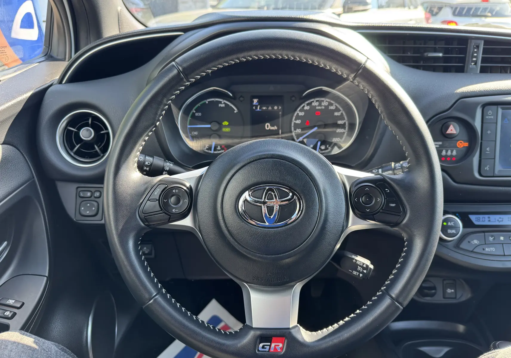 Vue intérieure centrée sur le volant noir de la Toyota Yaris Hybride GR Sport 2020 avec logo GR et tableau de bord visible.