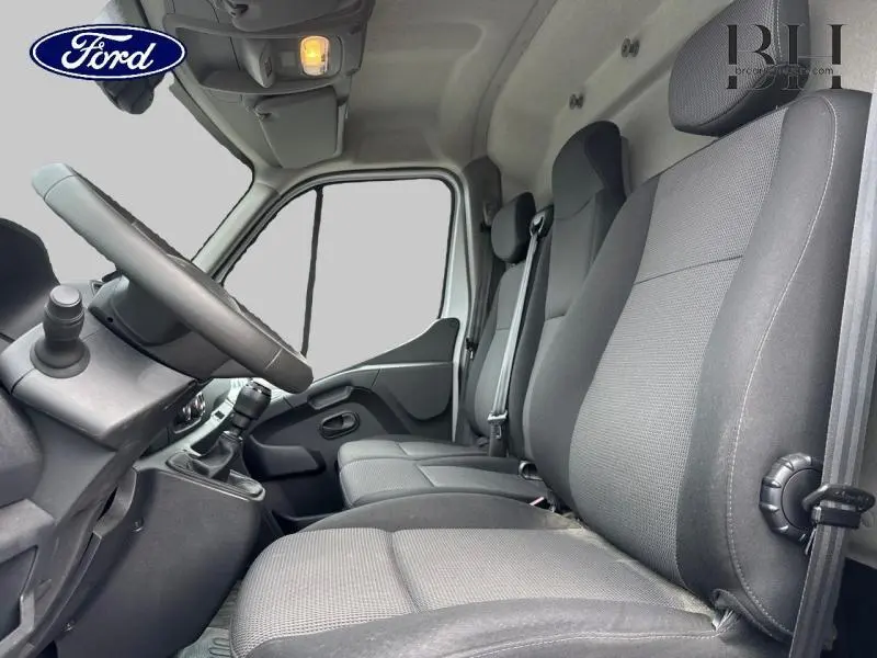 Intérieur du Renault Master 2022 montrant les sièges avant gris et la cabine avec volant et tableau de bord côté gauche.
