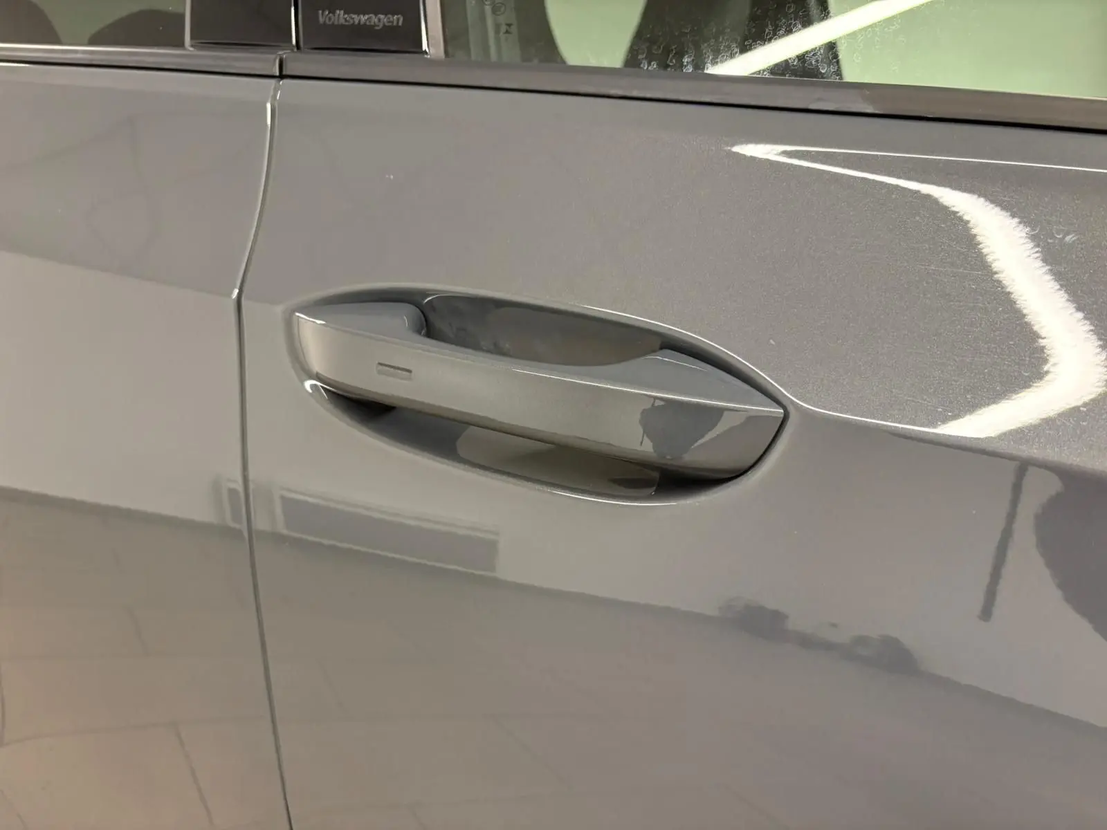 Poignée de porte côté gauche en gros plan sur Volkswagen Golf Gris Dauphin 2025 finition R-Line Edition.