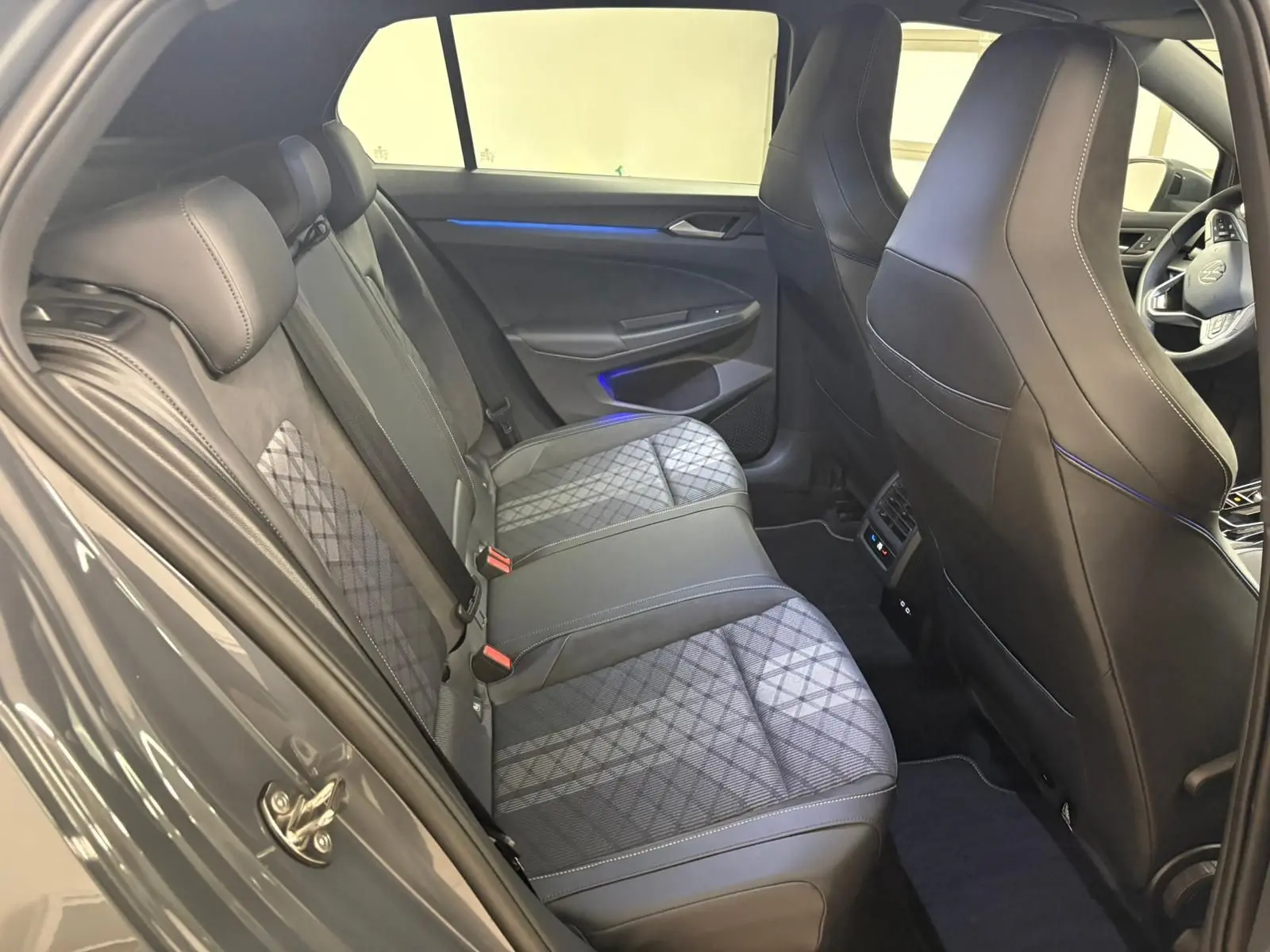Vue intérieure côté gauche montrant les sièges arrière en tissu gris et cuir noir de la Volkswagen Golf 2025 R-Line Edition.