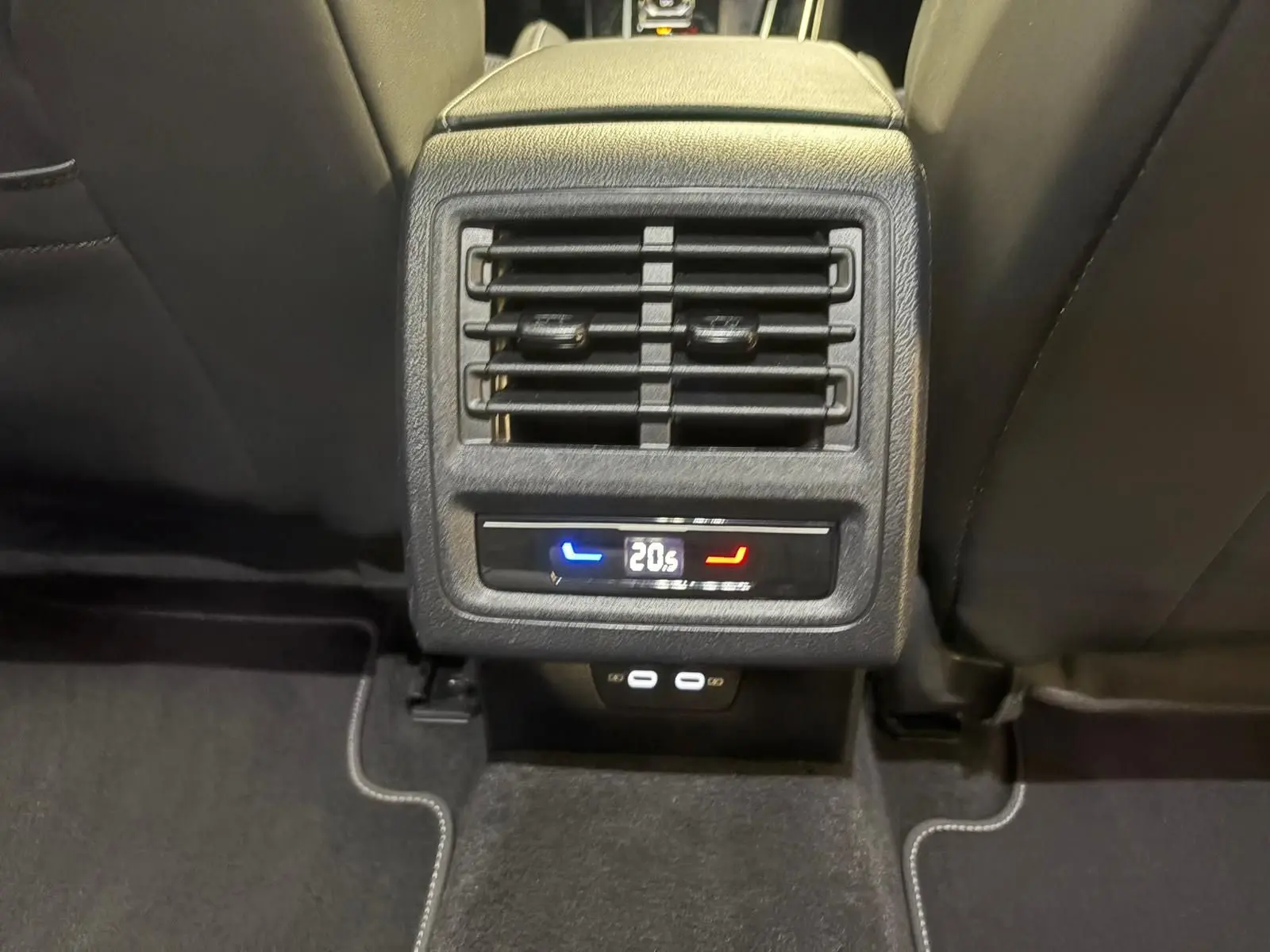 Vue rapprochée de la console arrière de la Volkswagen Golf gris dauphin, avec réglage de climatisation à 20,5°C et ports USB.