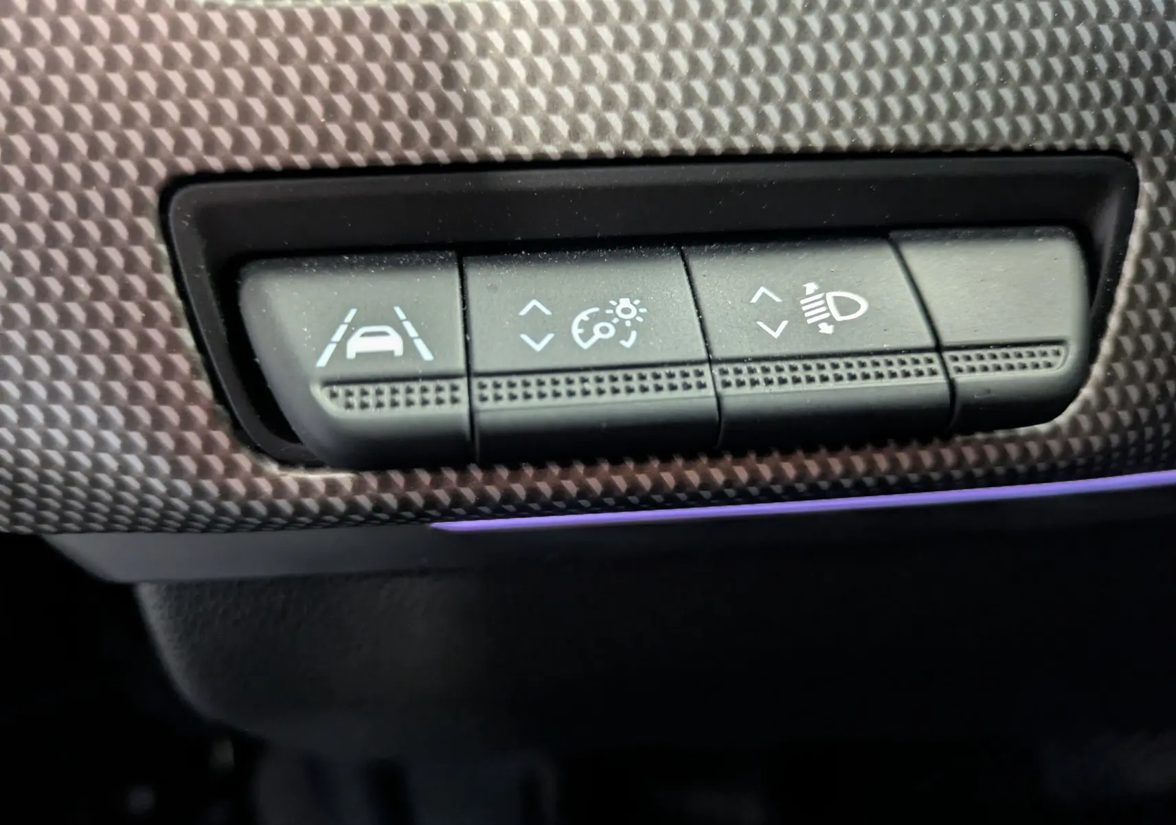 Gros plan sur les boutons de réglage d'assistance et d'éclairage dans l'habitacle du Renault Arkana noir 2023.