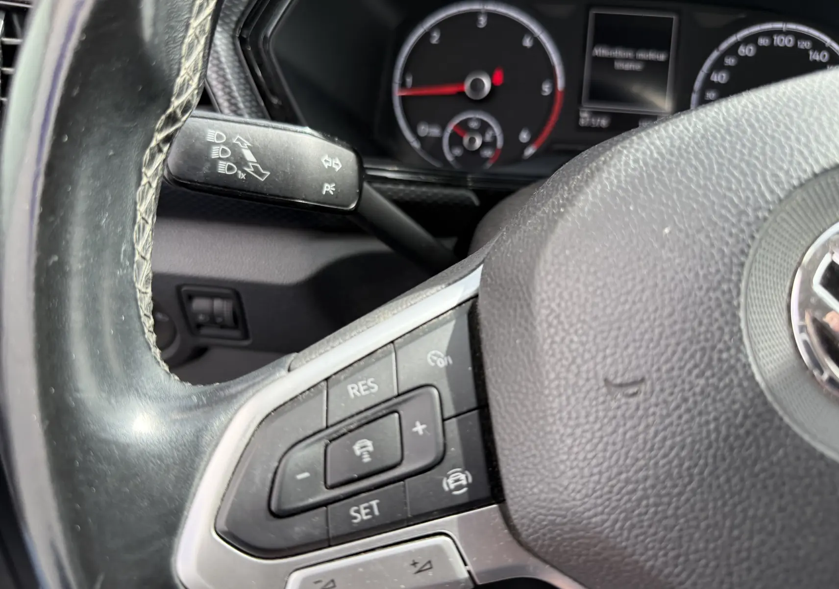 Gros plan sur le volant cuir noir et les commandes multifonctions côté gauche du Volkswagen T-Cross gris de 2019.