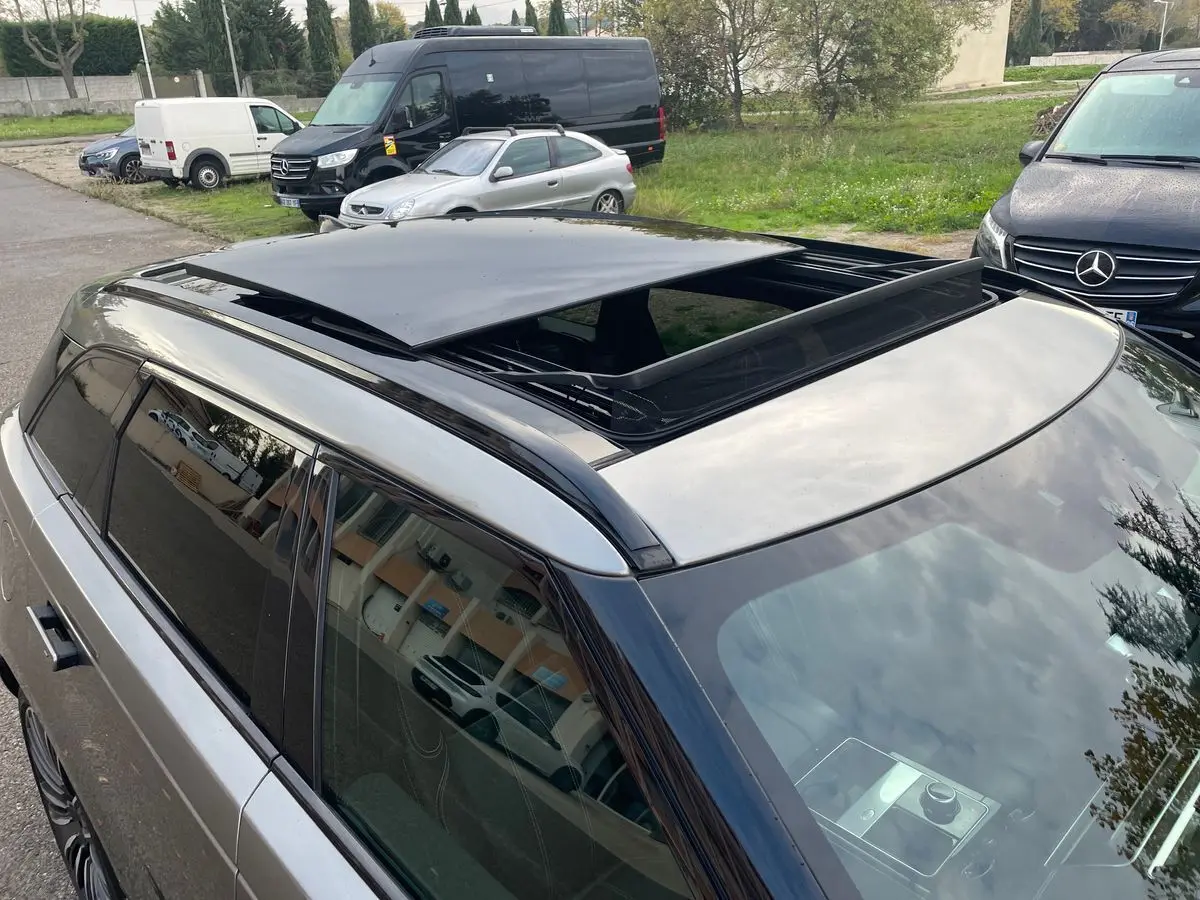 Vue en plongée du toit ouvrant ouvert d'un Range Rover Velar gris 2019, mettant en valeur sa finition noire brillante.