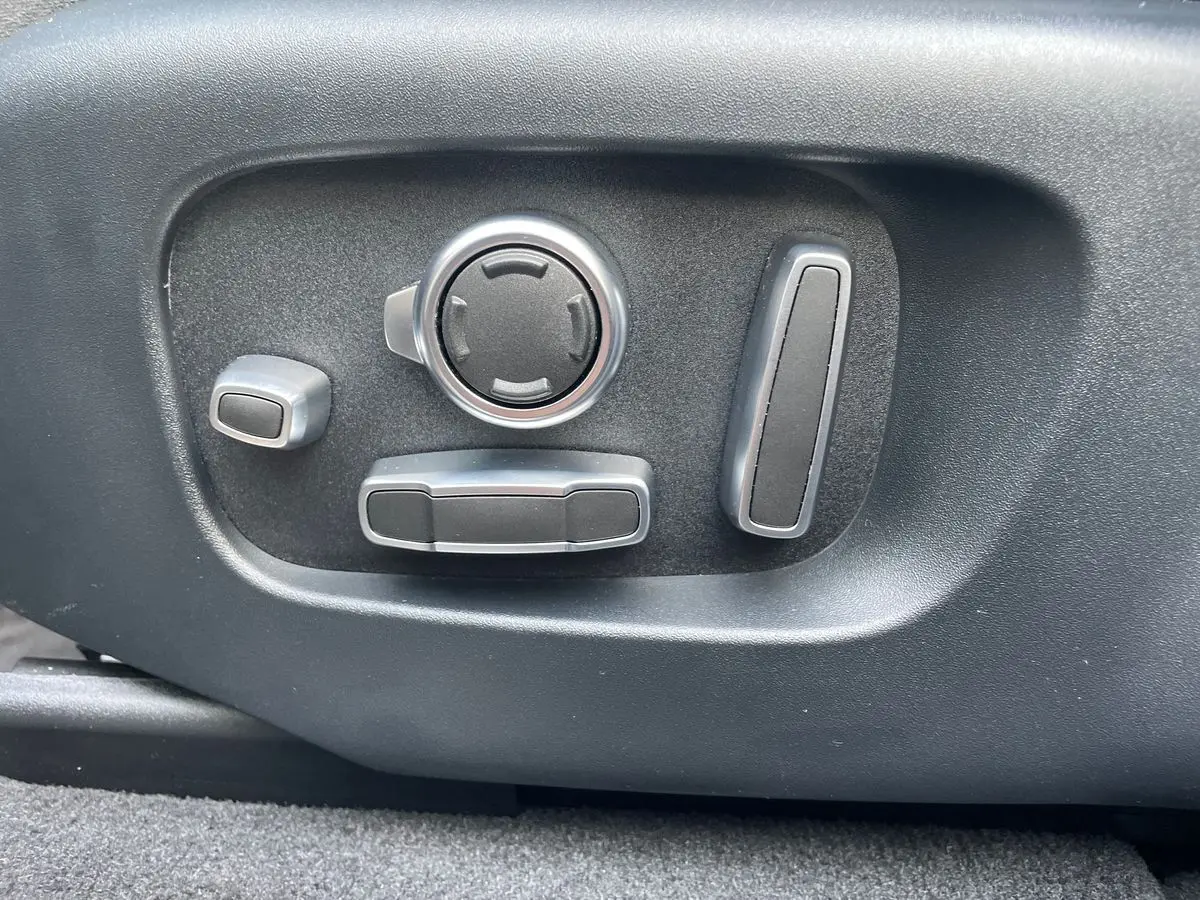 Gros plan sur les commandes de réglage électrique du siège côté conducteur du Range Rover Velar gris 2019.