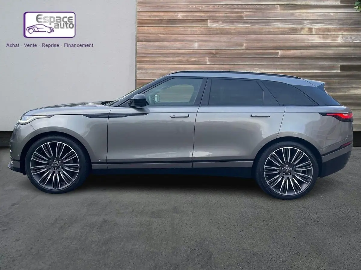 Profil droit d'un Range Rover Velar gris 2019 avec jantes alliage distinctives et toit noir contrastant.