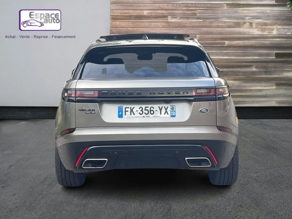 Vue arrière d'un Range Rover Velar gris 2019 avec plaques françaises, feux horizontaux et double sortie d'échappement rectangulaire.